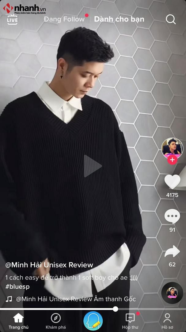 Một người đàn ông trẻ tuổi đang xem review thời trang trên điện thoại trước khi quyết định mua sắm