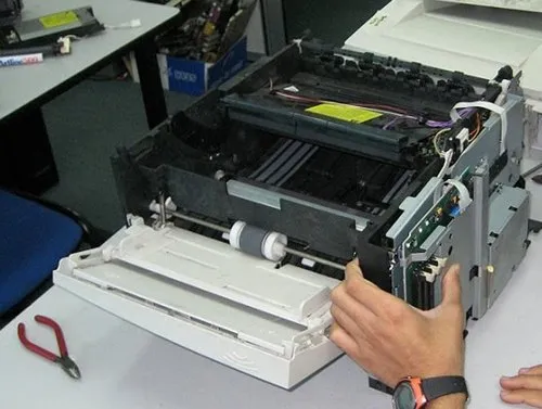 Kỹ thuật viên đang kiểm tra và sửa chữa máy in HP LaserJet