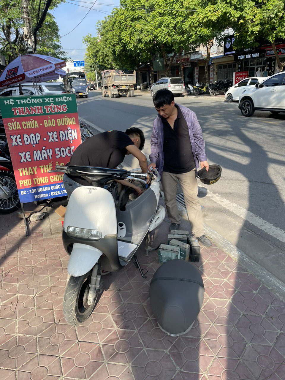 Người đàn ông đang kiểm tra và bảo dưỡng xe máy điện