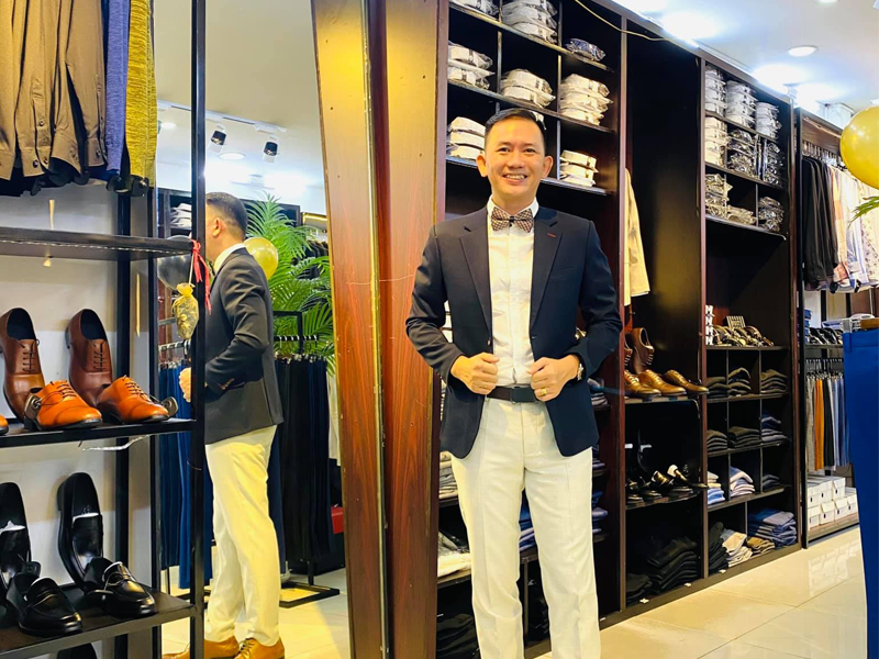 Một người đàn ông đang thử áo vest trong cửa hàng thời trang nam để đảm bảo vừa vặn và phù hợp