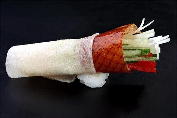 Cuốn bánh tráng với thịt vịt quay Bắc Kinh hành lá dưa chuột và nước sốt là cách thưởng thức phổ biến nhất