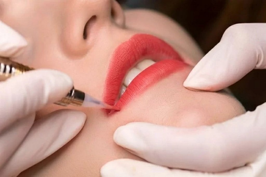 Người thợ phun xăm đang tỉ mỉ thực hiện phun môi cho khách hàng