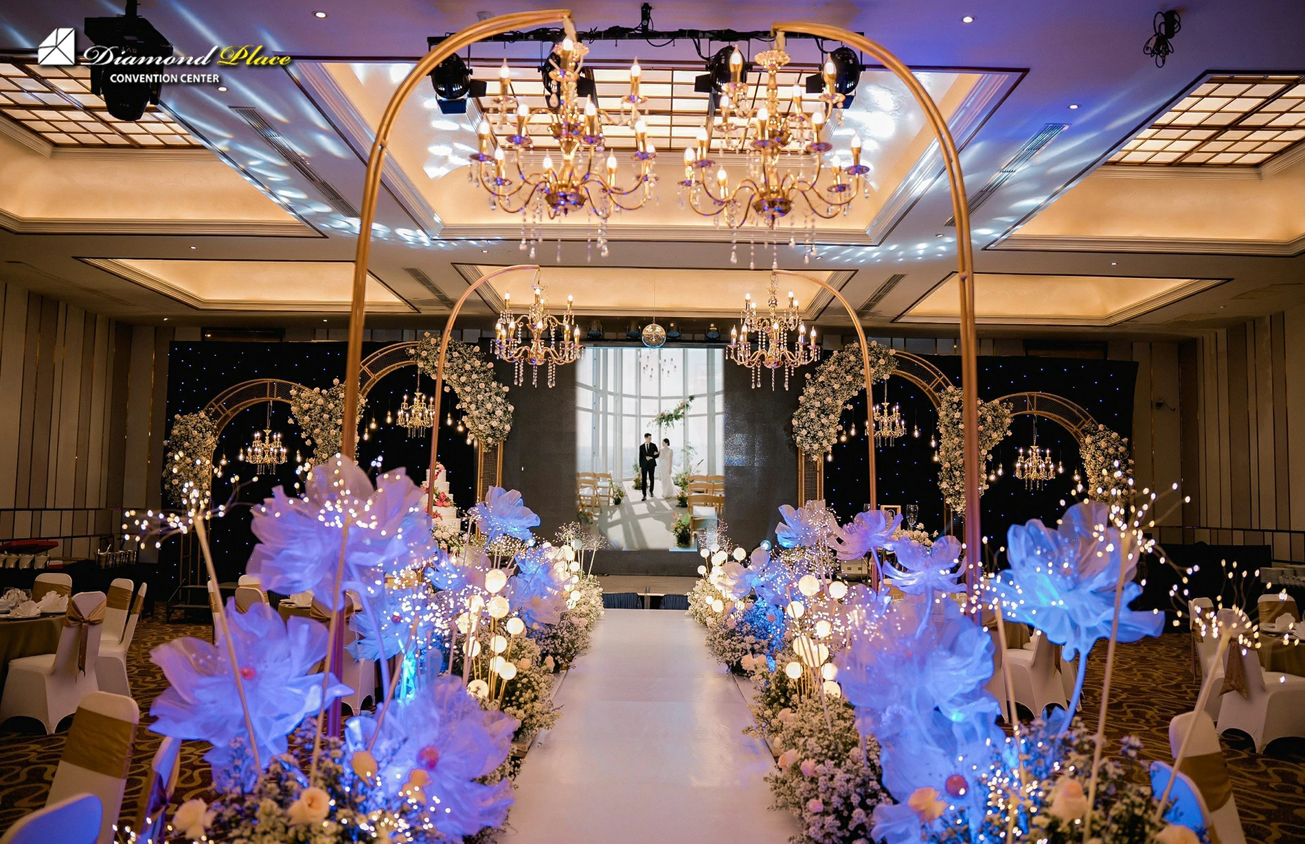 Sảnh tiệc cưới được trang trí lộng lẫy với hoa tươi và ánh sáng